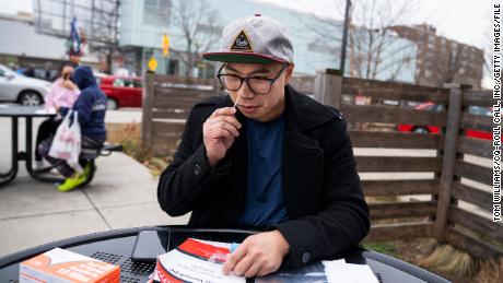 Aaron Salvador swabs his nose with a COVID-19 rapid antigen test kit outside